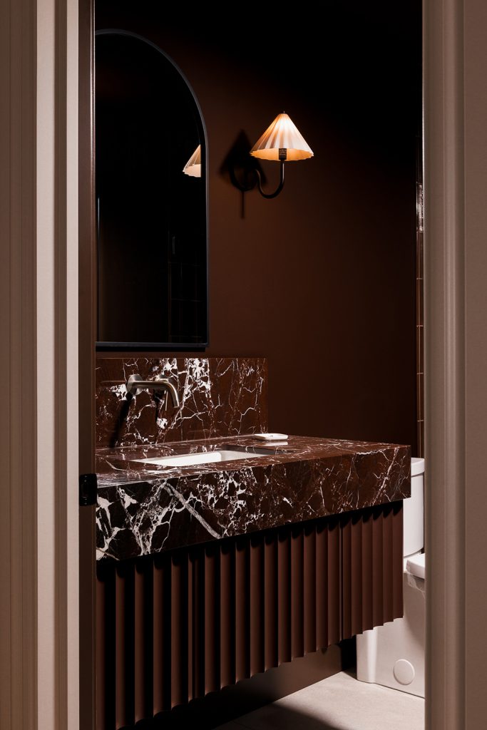 Colour drenched powder room with fluted vanity