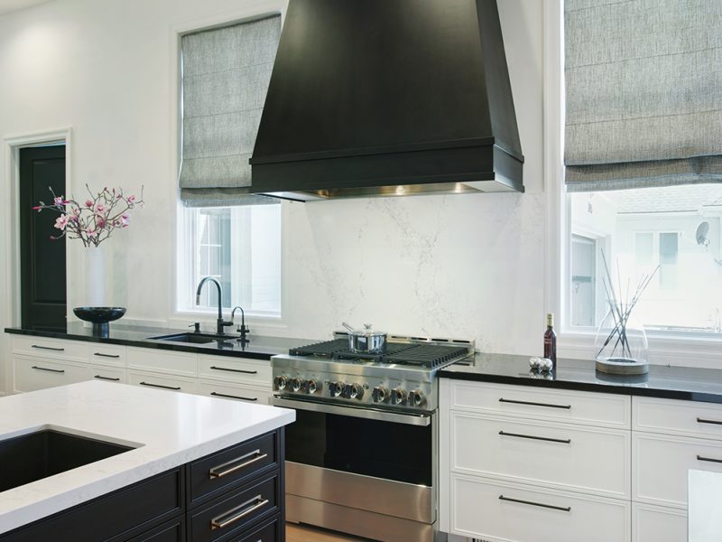 Oversized black hood with white painted cabinets