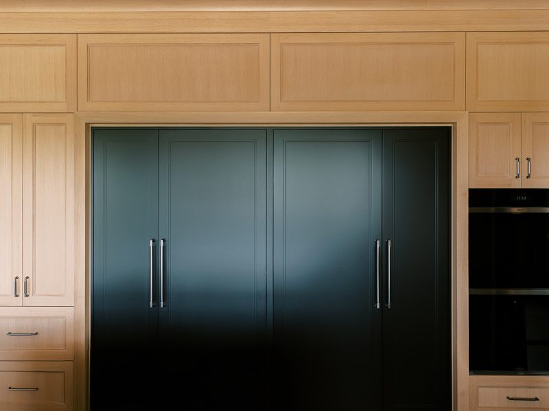 Black painted pantry doors inside kitchen