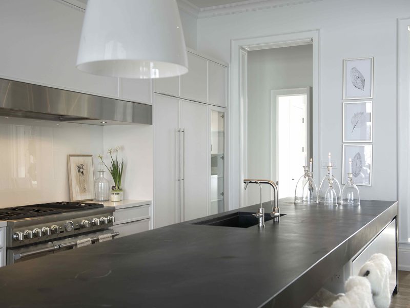 Black and white kitchen with stainless steel faucet and range hood