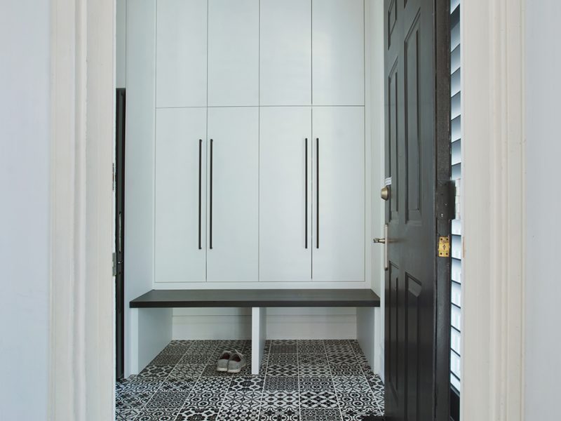 Black and white mudroom with tile floor