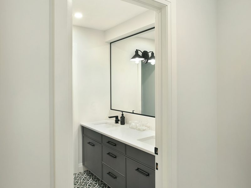Blue vanity in bathroom with patterned tile