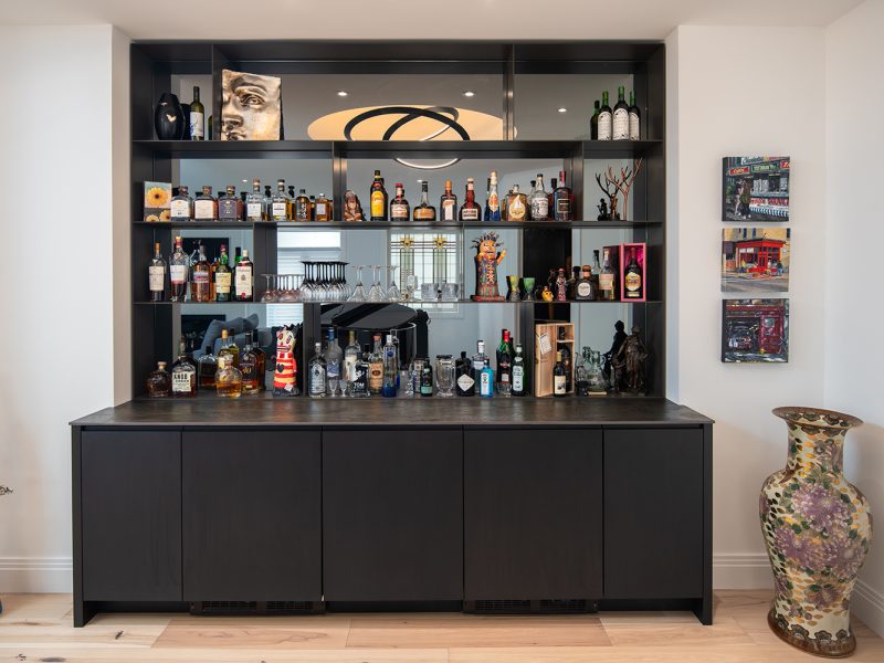 Home bar with open shelving and mirror