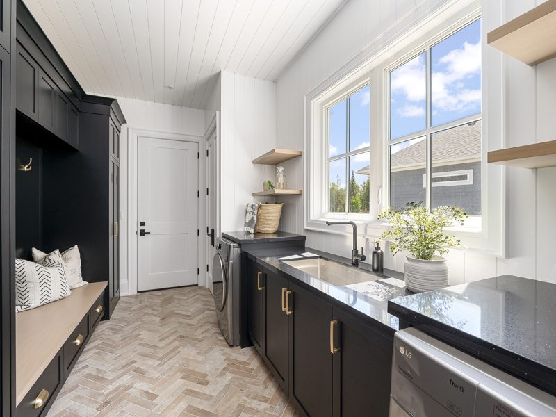 Dark laundry room cabinets with light floating shelves