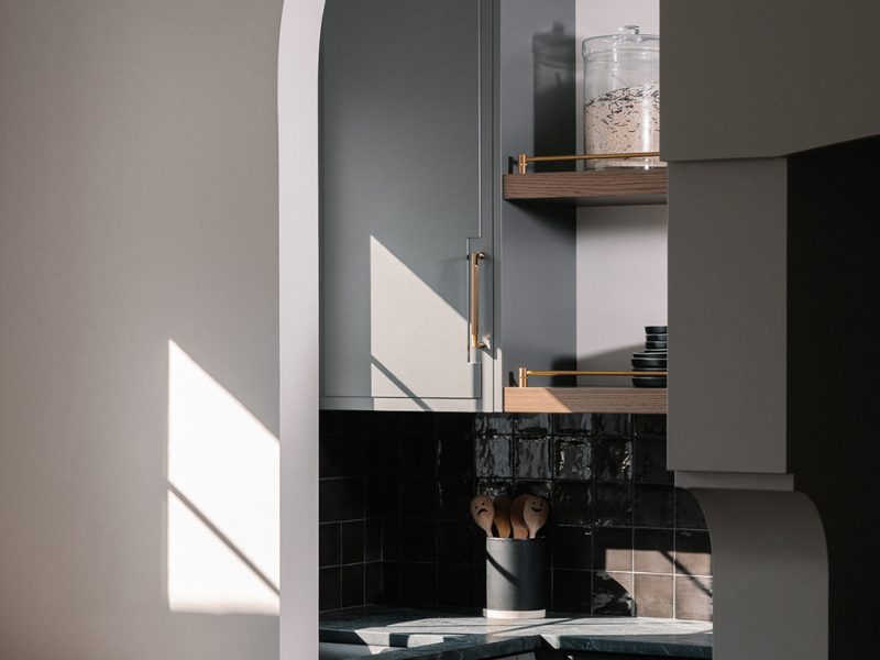 Curved archway into moody pantry