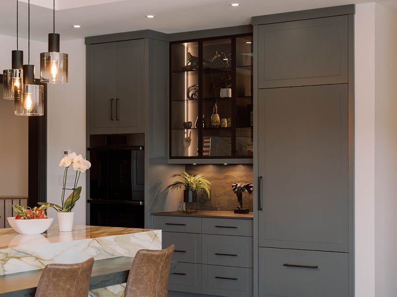 Grey kitchen cabinets with countertop and glass display cabinets