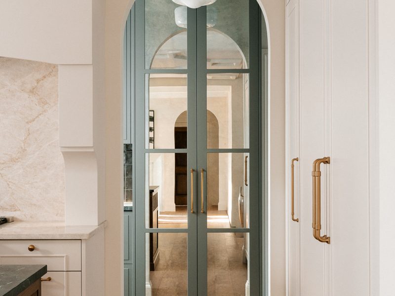 Archway into pantry with mirror front doors