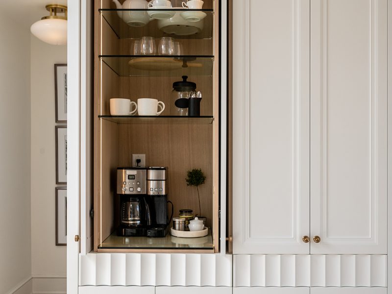 Hidden coffee cabinet with strip lighting and glass shelves