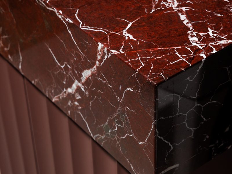 Red marble countertop on fluted vanity