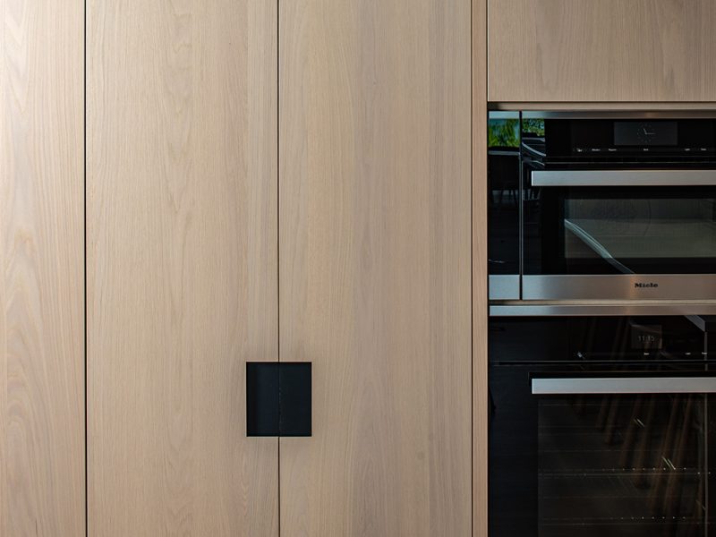 Tall wood cabinet with matte black hardware