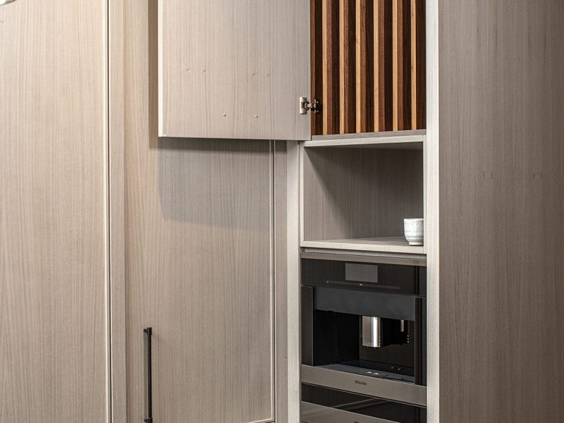 Vertical cutting board storage above microwave