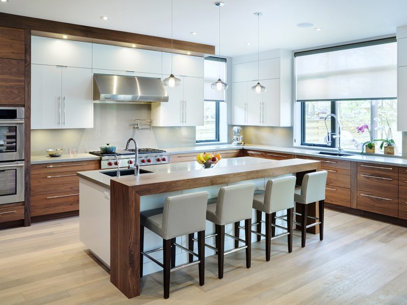 Waterfall wood countertop with bar seating in kitchen