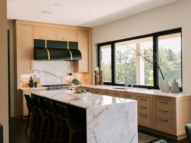 white oak kitchen cabinets with black range hood and dark island