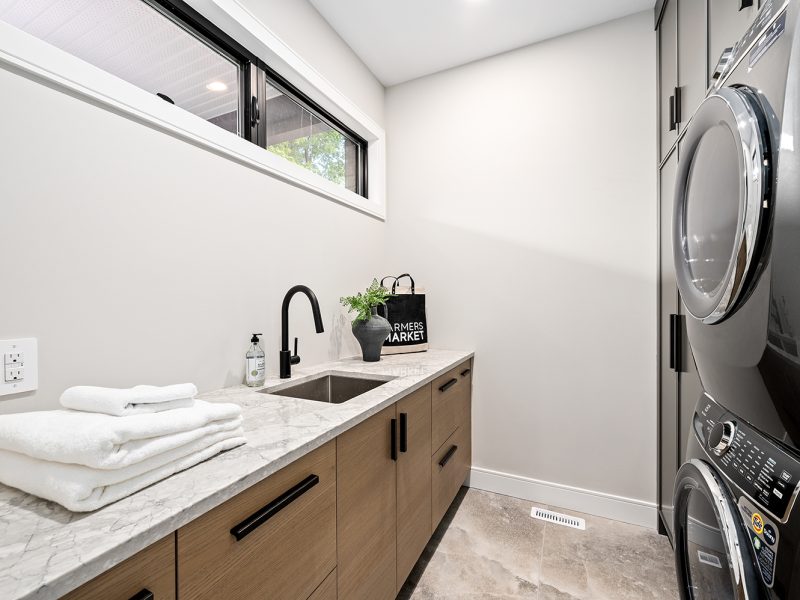 Dark oak laundry room cabinets with black hardware